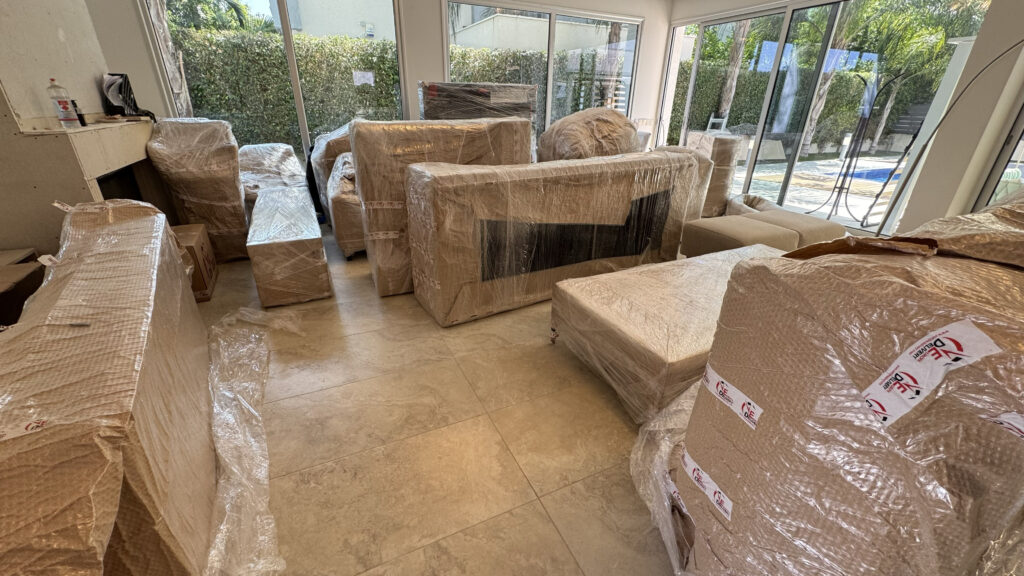 Europa Delivery professionals safely unloading large boxed items from a truck using a hydraulic tail lift during a complete furniture delivery and assembly in Limassol.